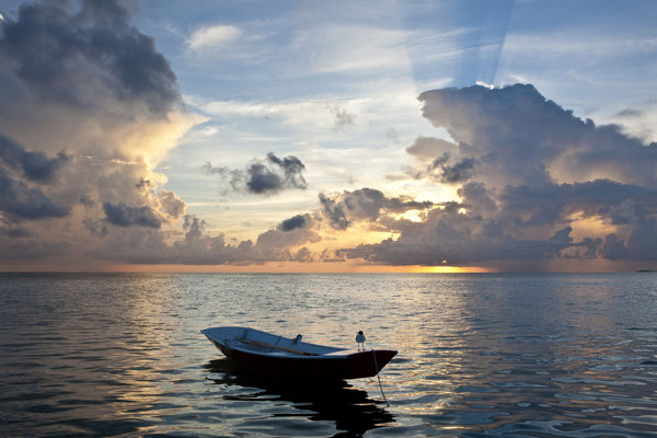 Dinghy boat in sea at sunset, Great Exuma Island, Bahamas