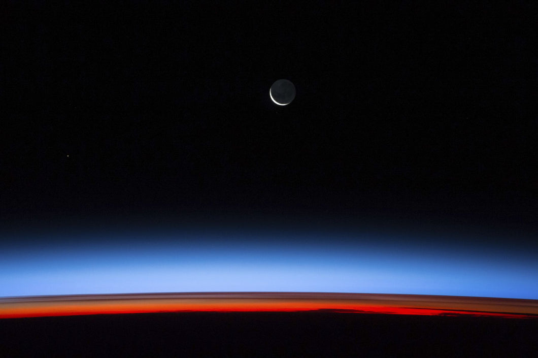 Satellite view of planet Earth showing sunset over Indian Ocean area with crescent moon in the sky