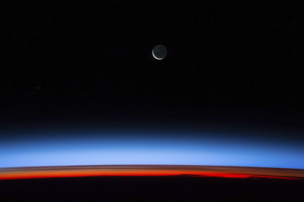 Satellite view of planet Earth showing sunset over Indian Ocean area with crescent moon in the sky