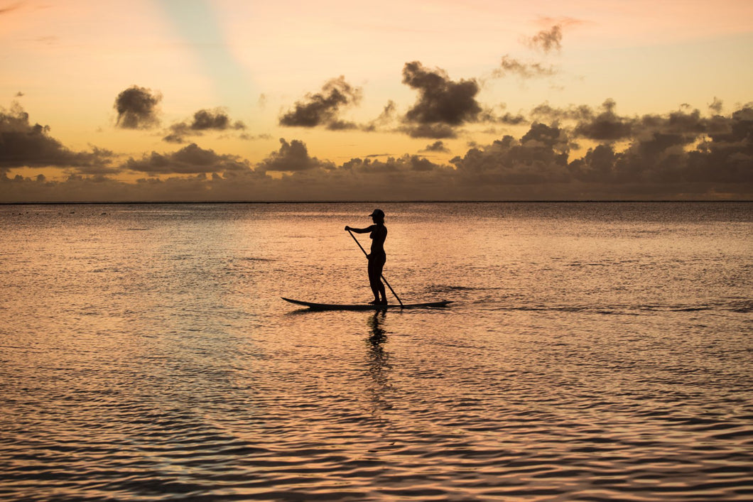 Silhouette of woman paddleboarding in the Pacific Ocean, Bora Bora, Society Islands, French Polynesia