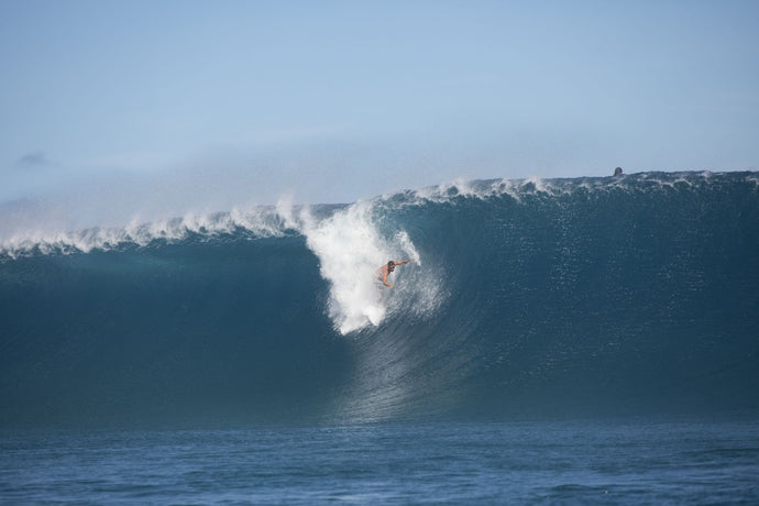 Surfer surfing wave in Pacific Ocean, Moorea, Tahiti, French Polynesia