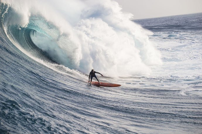 Male surfer surfing wave in Pacific Ocean, Peahi, Hawaii, USA