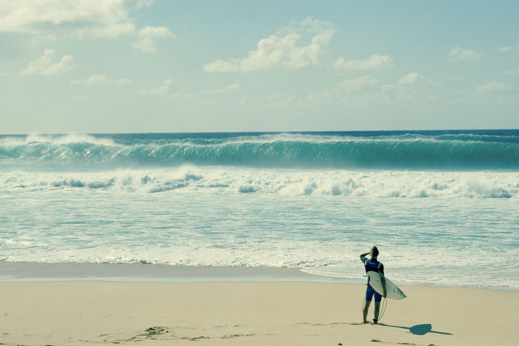 Surfer standing on the beach, North Shore, Oahu, Hawaii, USA