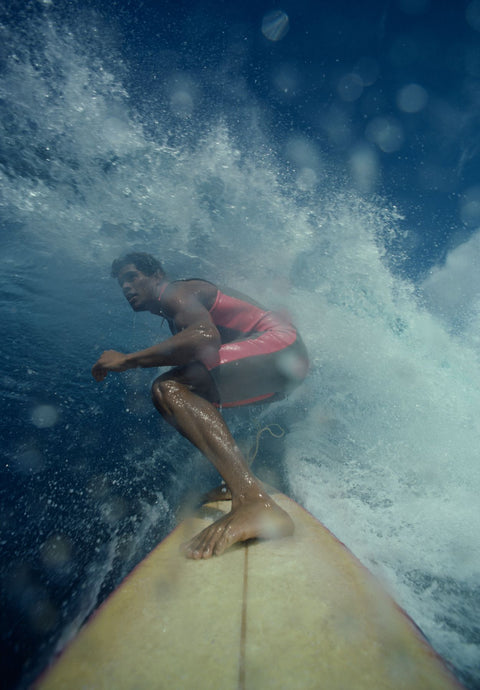 Surfer jumping over wave