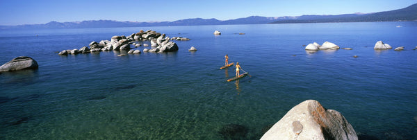 Two women paddle boarding in a lake, Lake Tahoe, California, USA
