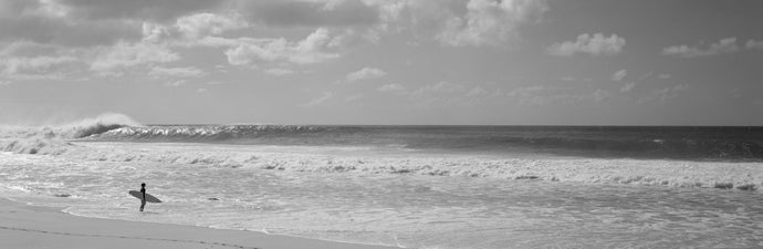 Surfer standing on the beach, North Shore, Oahu, Hawaii, USA
