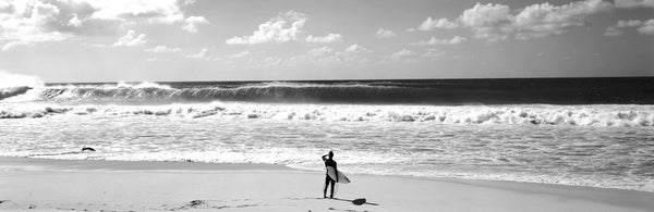 Surfer standing on the beach, North Shore, Oahu, Hawaii, USA