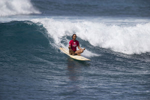 Woman meditating on paddle board in ocean, Hawaii, USA