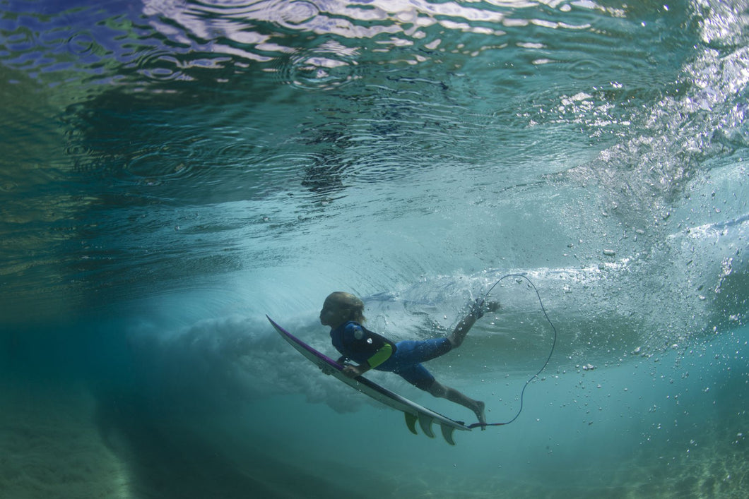 Underwater view of a surfer duck diving in ocean, Hawaii, USA
