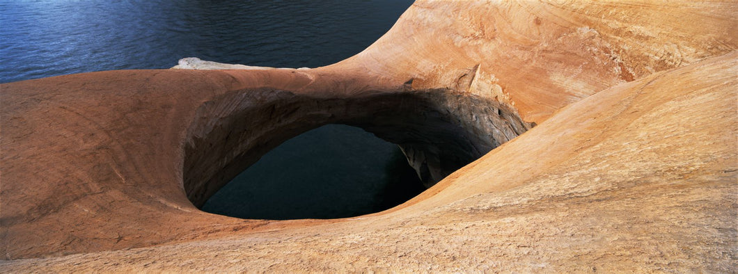 High angle view of a pothole arch at a lakeside, Lake Powell, Utah, USA