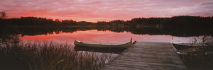 Canoe tied to dock on a small lake at sunset, Sweden